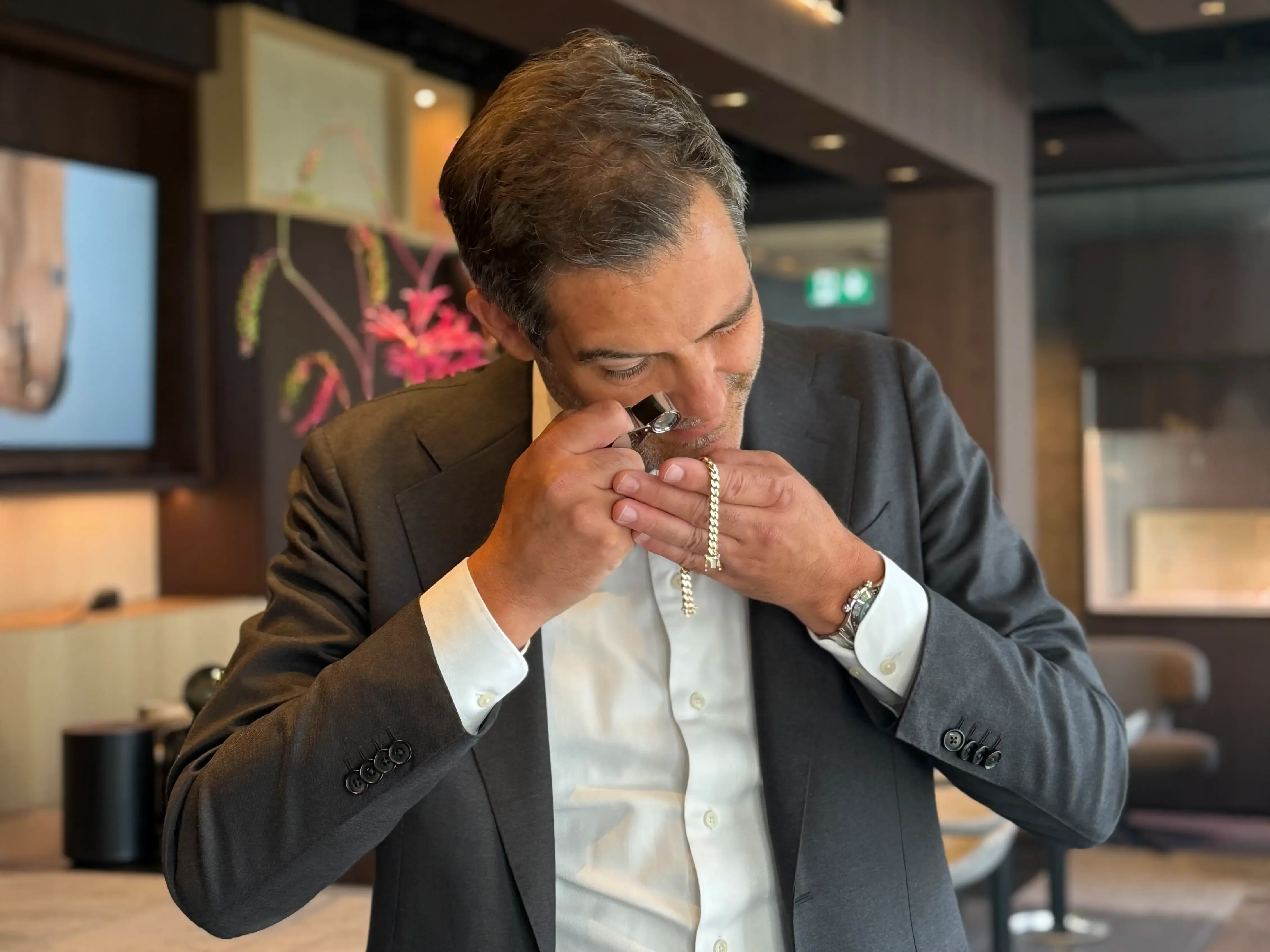 Juwelier Techel im Anzug prüft Schmuck