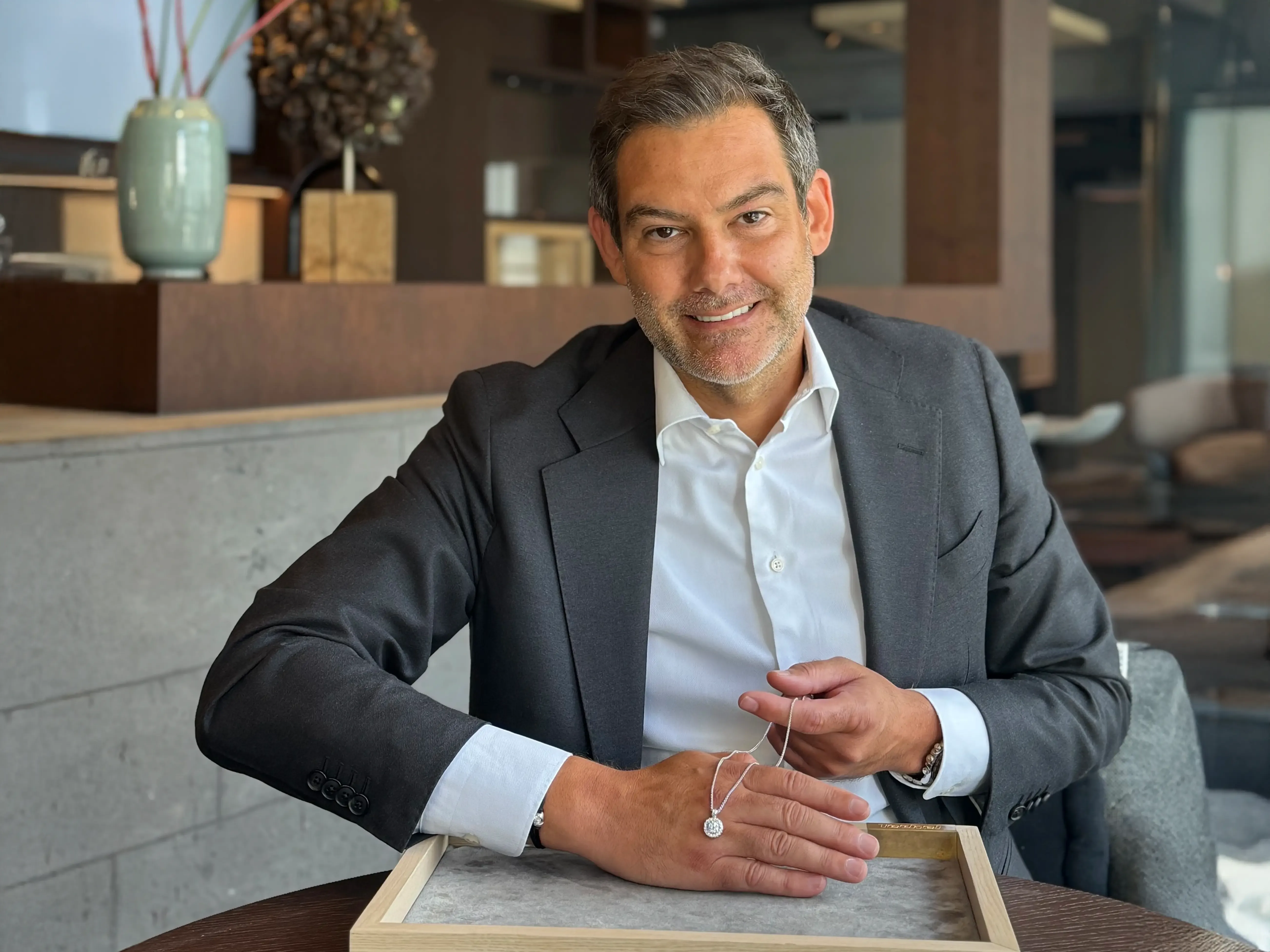 Juwelier Techel im Anzug zeigt Schmuck